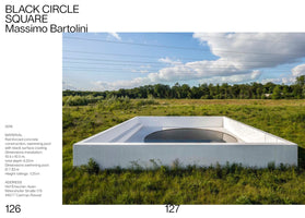 A page from a publication featuring Massimo Bartolini's artwork, BLACK CIRCLE SQUARE. The image displays a white, square concrete structure set in a lush green field. Inside the structure is a large, circular black swimming pool. The background shows a line of trees under a blue sky with white clouds and power lines. A text column on the left provides details about the 2016 installation, including its materials, dimensions, and location.