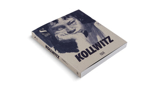 An angled shot of a paperback book titled Kollwitz, resting on a white surface. The beige cover features a dark blue, expressive, sketch-like portrait of a person resting their chin on their hand in a pensive pose. The title is in a large, bold, dark blue font.