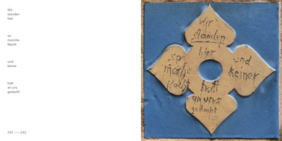 A two-page book spread. On the left page is a German poem typed in black: Wir standen hier so manche Nacht und keiner hatt an uns gedacht. The right page shows a square blue ceramic tile with a raised, sand-colored, four-lobed design in the center. The same poem is handwritten in a black, cursive script onto the four lobes of the design, which surrounds a central circular hole.