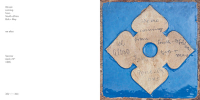A two-page book spread. The left page features typed text against a white background: We are coming from South-Africa, Bob + May, we allso, Sacrow, April, 23th, 1995. The right page shows a close-up photograph of a bright blue tile. On the tile is a weathered, tan paper cutout in a quatrefoil shape with a central hole, bearing the same text handwritten in cursive.