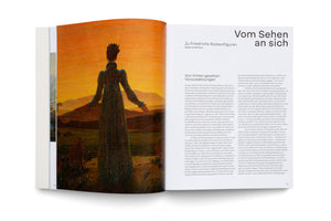 An open book with a two-page spread. The left page shows a full reproduction of a Romantic painting of a woman in a dark dress, seen from behind, looking out over a hilly landscape under an orange sky. The right page contains an essay in German.