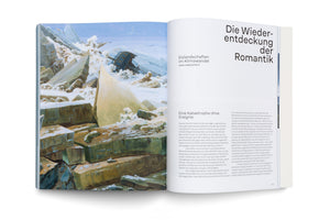 An angled, overhead view of an open book on a white surface. The left page shows Caspar David Friedrich’s painting The Sea of Ice, where a wooden ship is wrecked and crushed by massive, sharp sheets of ice. The right page contains German text under the large headline Die Wiederentdeckung der Romantik.