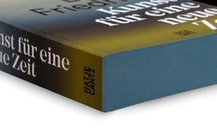 A close-up, angled shot of the corner of a book on a white background. The cover has a blue and yellow-green gradient with white German text. The publisher, Hatje Cantz, is visible on the spine. The page edges are a solid, textured blue-green color.