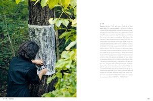 A two-page spread from a book. On the left, a photograph shows an artist with dark, wavy hair in a forest, making a rubbing of a tree's bark. The artist, wearing black, presses a large sheet of paper onto the tree trunk, creating a black-and-white textured impression. On the right page, a block of text describes the artwork, titled Inzision.