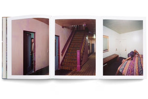An open photobook displays a spread with three vertical color photographs of scenes in a residential building. On the left, a man peeks from a doorway. In the center is a carpeted staircase with a purple post. On the right, a person in a purple robe reclines on a bed, looking at the camera.