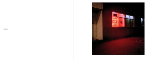 A two-page book spread. The left page is white with the text Plate 42 Nightglow. The right page displays a color photograph of a building at night. A red neon sign in the window reads BRUNSWICK CLUB OPEN, casting a vibrant red glow onto the dark pavement below.