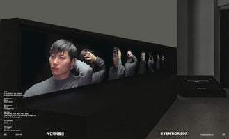 A two-page spread from an art catalog showing a dark gallery installation. The main feature is a long video screen displaying a close-up of a pensive East Asian man in a gray sweater holding the back of his head. Behind him, a line of identical figures in the same pose recedes into the darkness. The page includes Korean text and the English title EVENT HORIZON.