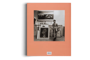 The back of a salmon-colored book featuring a black-and-white photograph of an artist in his studio. The man, wearing glasses, stands amidst framed paintings, holding a small wooden folding rack. A barcode and publisher information are printed below the photograph.