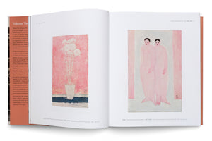 An open hardcover art book is laid flat, showing a two-page spread on a white surface. The left page displays a painting of white chrysanthemums in a vase against a textured pink background. The right page features a stylized painting of two standing female nudes with pale pink skin and dark hair.