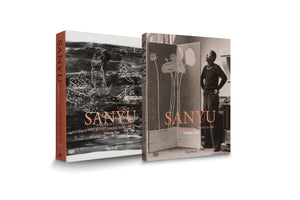 A product shot of two hardcover art books titled SANYU: His Life and Complete Works in Oil by Rita Wong, standing upright against a white background. Volume One, on the right, has a black-and-white photo of the artist in his studio. Volume Two, on the left, features a black-and-white abstract painting and has a rust-colored spine.