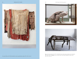 A two-page spread from an art book. On the left, page 91, a large wall-mounted artwork consists of layered, tattered, and discolored blankets in shades of beige, red, and brown. On the right, page 92, under the name Berlinde De Bruyckere, are two sculptures. The top image shows a pale, fleshy, abstract form in a glass case. The bottom image shows a dark, gaunt, horse-like figure lying on a wooden table.
