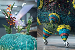A split image showing details of colorful, woven sculptures. On the left, artificial plants like a bird of paradise and a cactus emerge from turquoise, dome-shaped woven planters. On the right, a close-up shows a large, intricately woven sculpture in blue, yellow, and red, with cone-shaped legs on caster wheels.