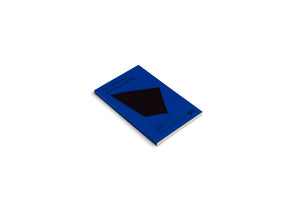 A book with a solid royal blue cover titled On Architecture and Greenwashing lies at an angle on a white background. The cover features a large, black, four-sided geometric shape in the center. Below the shape, the text reads The Political Economy of Space Vol. 1, Ed. Charlotte Malterre-Barthes.