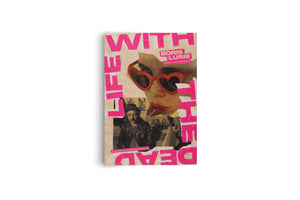 An angled view of a collage-style book cover or poster on a white background. Large, bright pink, cut-out letters spell out WITH LIFE THE DEAD. The design, celebrating the Boris Lurie 100th Anniversary, features a photo of a woman in red heart-shaped sunglasses and a black-and-white portrait of a man in a hat.