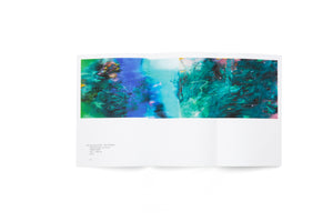 A bird's-eye view of an open art catalog on a white surface. The two-page spread showcases a vibrant, abstract painting dominated by shades of green, teal, and blue, with energetic, calligraphic strokes. Below the image on the left page is the caption for the artwork, The Spring of 2020.