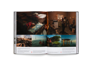 An open book displaying a two-page photo essay. The top of the left page shows a young girl sleeping on a bed in a modest room. The top right shows a woman holding a child in a rustic kitchen. The bottom half features four smaller photos: a busy port at sunrise, people swimming in a lake, children sitting by green water, and a person diving off a wooden pier at sunset.