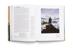 An open art book laid flat, showing a two-page spread about Caspar David Friedrich's painting, Wanderer above the Sea of Fog. The famous painting is on the right page, while the left page contains German text analyzing the artwork and a smaller pencil sketch of a rocky peak.
