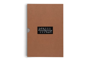 A front view of a brown cardboard slipcase standing vertically against a white background. In the center is a black rectangular sticker with a white line drawing of a complex, oscillating wave. A thumb notch is visible on the left side.