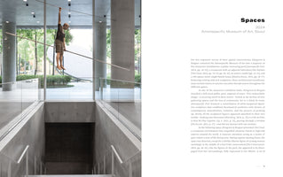 A two-page spread from an art publication. The left page shows a photograph of a modern, concrete museum interior where a realistic sculpture of a young man hangs by one arm from a high wire. He is suspended over a deep, open stairwell. The right page features the title, Spaces, 2024, Amorepacific Museum of Art, Seoul, followed by descriptive text about the exhibition.