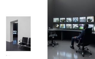 A two-panel image showing a stark contrast between a public and a private space. On the left, a bright, empty waiting area with white walls and black chairs leads to a dark room. On the right, a Black man in a suit sits in a dimly lit security control room, monitoring a large bank of twelve surveillance screens.