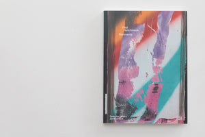 A book titled Remnants by Paul Hutchinson, with a subtitle Selected Works 2019-2024, lies on a plain white surface. The cover features a colorful, abstract design with spray-painted and distressed textures in shades of orange, purple, pink, and turquoise.