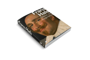 An angled photograph of a thick book with a black cover, resting on a white surface. The cover features a close-up of a classical painting of a man with a large, curled mustache and a white ruff collar. The title on the cover reads Frans Hals, Meister des Augenblicks in white text.
