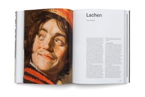 An open art book on a white background. The left page features a classical oil painting of a young person with a wide, expressive smile looking upward. The right page has German text under the large, bold heading Lachen.