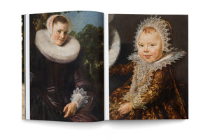 An open art book lies flat against a white background, displaying two historical portraits. The left page shows a painting of a smiling woman in a dark dress with a large white ruff collar and lace cap. The right page features a portrait of a baby in an ornate gold and brown brocade gown with a large, intricate lace bonnet and bib.