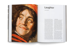 A photograph of an open book laid flat. The left page features a close-up of a classical oil painting of a young person with dark hair, looking upwards with a wide, laughing expression. The right page is a chapter titled Laughter by Friso Lammertse, with explanatory text in two columns.