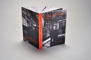 A hardcover book titled Call Me Lola: In Search of Mother by Loli Kantor, standing upright and slightly open on a light gray surface. The cover features black-and-white photographs of women on a city street, with a bright orange-red spine displaying the title in black text.