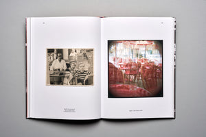 An open book on a grey background. The left page displays a vintage black-and-white photograph of a man and two children sitting at a cafe table. The right page has a blurry, dreamlike color photograph of an empty cafe with rows of red wicker chairs.