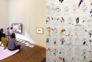 A diptych showing an art gallery workshop. On the left, a group of adults and children sit and stand on a wooden floor, watching a screen that displays pink flowers. On the right, a wall is covered with children's art projects featuring outlines of hands decorated with colorful paint, paper, and feathers.