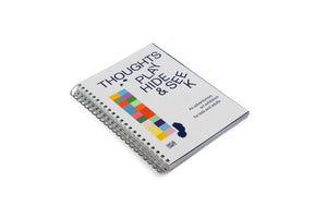 A spiral-bound book with a white cover lies on a plain white background. The cover has dark blue text that reads THOUGHTS PLAY HIDE & SEEK. Below the title is a vertical column of multicolored squares and smaller text that says An adventurous art exhibition for kids and adults.