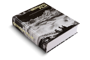 A thick hardcover book titled German Film, shown at an angle on a white surface. The black-and-white cover features a still of a film crew on a snowy mountain range under a starry sky. The title is printed in a pale yellow, sans-serif font.