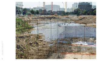 A double exposure photograph of a large urban construction site. The image layers a deep, muddy excavation pit with a semi-transparent view of a concrete foundation being built within it by workers. In the background, city buildings and construction cranes are visible.