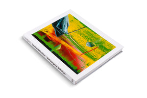 A white hardcover art book, titled Gerhard Richter Verborgene Schätze, lies at an angle on a white surface. The cover features a vibrant, textured abstract painting with prominent strokes of yellow, green, red, and dark blue.