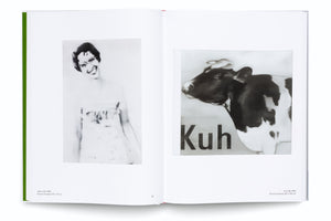 An open art book with a green spine shows a two-page spread against a white background. On the left page is a blurry, black-and-white portrait of a smiling woman. The right page features a black-and-white painting of a cow's head in profile, with the word Kuh printed in large, black letters below it.