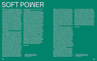 A two-page spread from a publication on a solid teal background. The words SOFT POWER are written in a large, white, sans-serif font at the top. Below the title, the text is arranged in two columns, with German on the left and English on the right, describing an exhibition about the cultural and political power of textiles. Page numbers 12 and 13 are visible at the bottom.