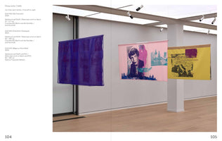 An exhibition view in a modern gallery with white walls and a wood floor, showing three large silkscreen prints on fabric by Philipp Gufler hanging from the ceiling. From left to right: a sheer purple banner, a pink banner with a portrait of a person, and a yellow banner with a map of Europe. Text describing the art is on the far left wall.