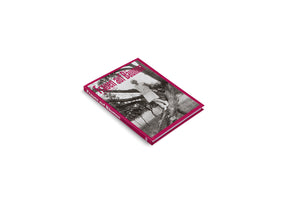 A magenta hardcover book titled Frauen auf Bäumen, angled on a white background. The cover features a vintage black-and-white photo of a woman in a light-colored dress and hat standing on the branch of a large tree.
