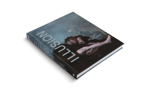 A hardcover book titled ILLUSION, presented at an angle on a white background. The cover features a somber painting of a person reclining under a dark sky with a crescent moon. A subtitle in German, TRAUM IDENTITÄT WIRKLICHKEIT, is also visible.