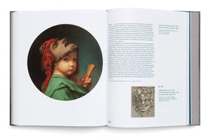 An open art book is displayed at an angle, showing a two-page spread. The left page features a large, circular painting of a young child in a green tunic, holding a dramatic mask with red hair on their forehead. The right page contains German text and a smaller black-and-white illustration of a grotesque mask.