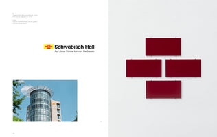 A two-page book spread in German about the company Schwäbisch Hall. The left page shows the company's logo, slogan, and a photo of its modern office building. The right page displays an artwork of four dark red rectangular panels on a white wall, arranged in the shape of the logo.