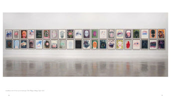 A wide installation shot of a white gallery wall displaying two long, horizontal rows of framed artworks. The numerous paintings are colorful, abstract portraits, and their images are reflected on the polished concrete floor below.