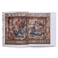 A photo of an open art book showing a two-page illustration. The artwork blends a classical style with modern themes, featuring people in punk-rock attire alongside classical nudes in a room resembling ancient ruins. The ornate border incorporates video game interface elements and a figure resembling Lara Croft holding two pistols.