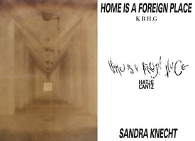 The book cover for Home is a Foreign Place by Sandra Knecht. On the left is a blurry, sepia-toned photo of a long, empty institutional hallway. The right side is white, featuring the title in both a bold print font and a scratchy handwritten script, along with the author's name and the publisher, Hatje Cantz.