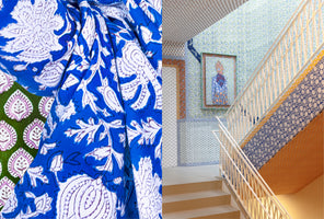 A diptych image contrasts a close-up of a draped blue and white block-printed fabric with a view of a maximalist interior. On the right, a staircase with a white railing is surrounded by walls, a ceiling, and framed art, all covered in a colorful patchwork of various floral and geometric patterned wallpapers.