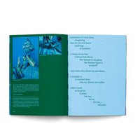 An open book with a two-page spread. The left page is dark green, featuring two photographs of a figure in shimmering blue fabric above a block of text. The right page is light blue and contains a poem with staggered, centered lines about choice and self-creation.