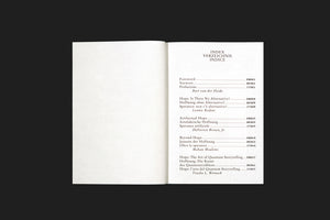 An overhead shot of an open book on a black surface. The left page is blank. The right page is a table of contents titled INDEX, VERZEICHNIS, INDICE, with entries listed in English, German, and Italian.