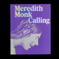 A purple book cover with the title Meredith Monk Calling in a large, iridescent serif font. Below the title is a stylized, duotone profile photograph of a woman with braided hair, smiling with her eyes closed. The book is set against a black background.